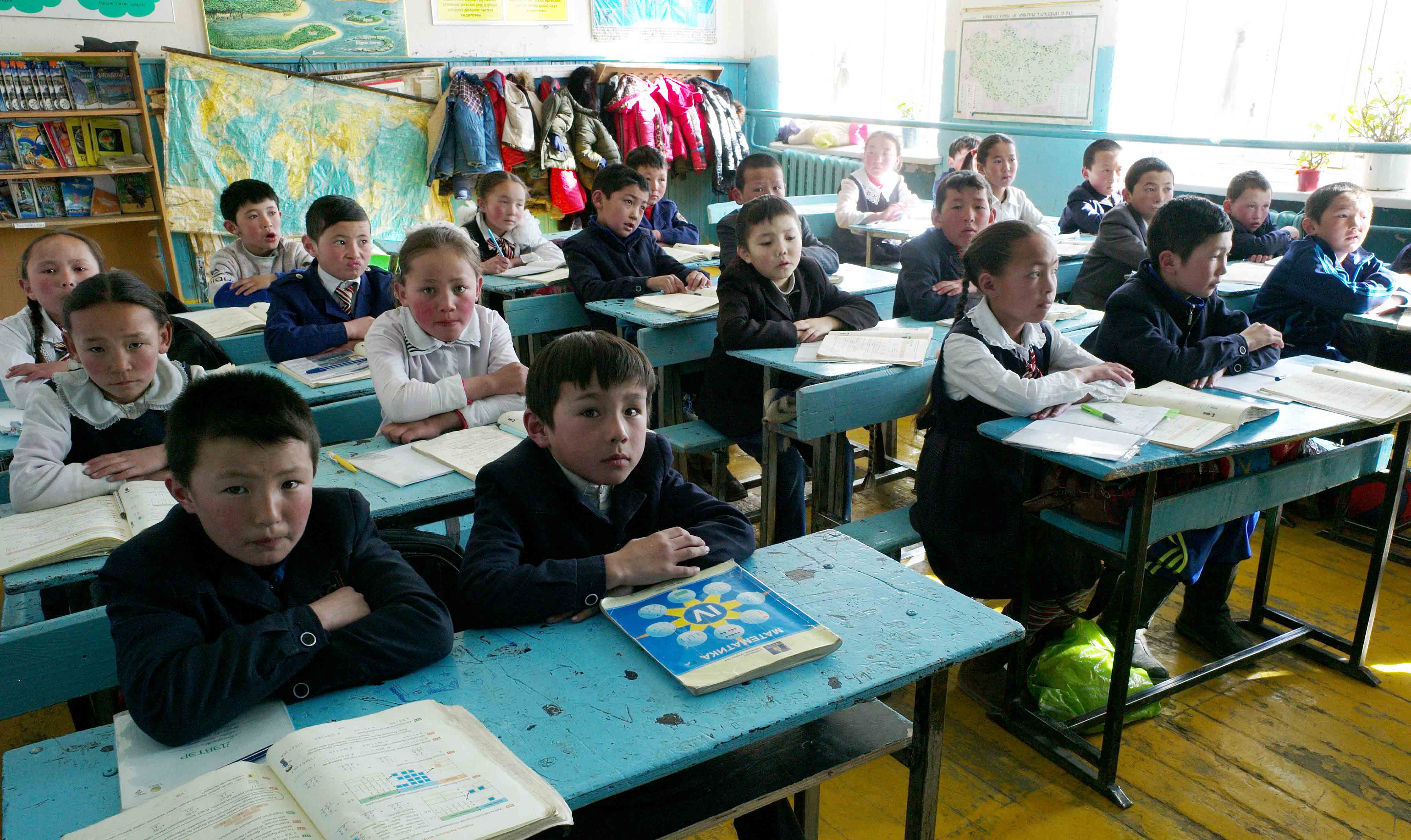 Akerke, second row second desk back in white, in her classroom.