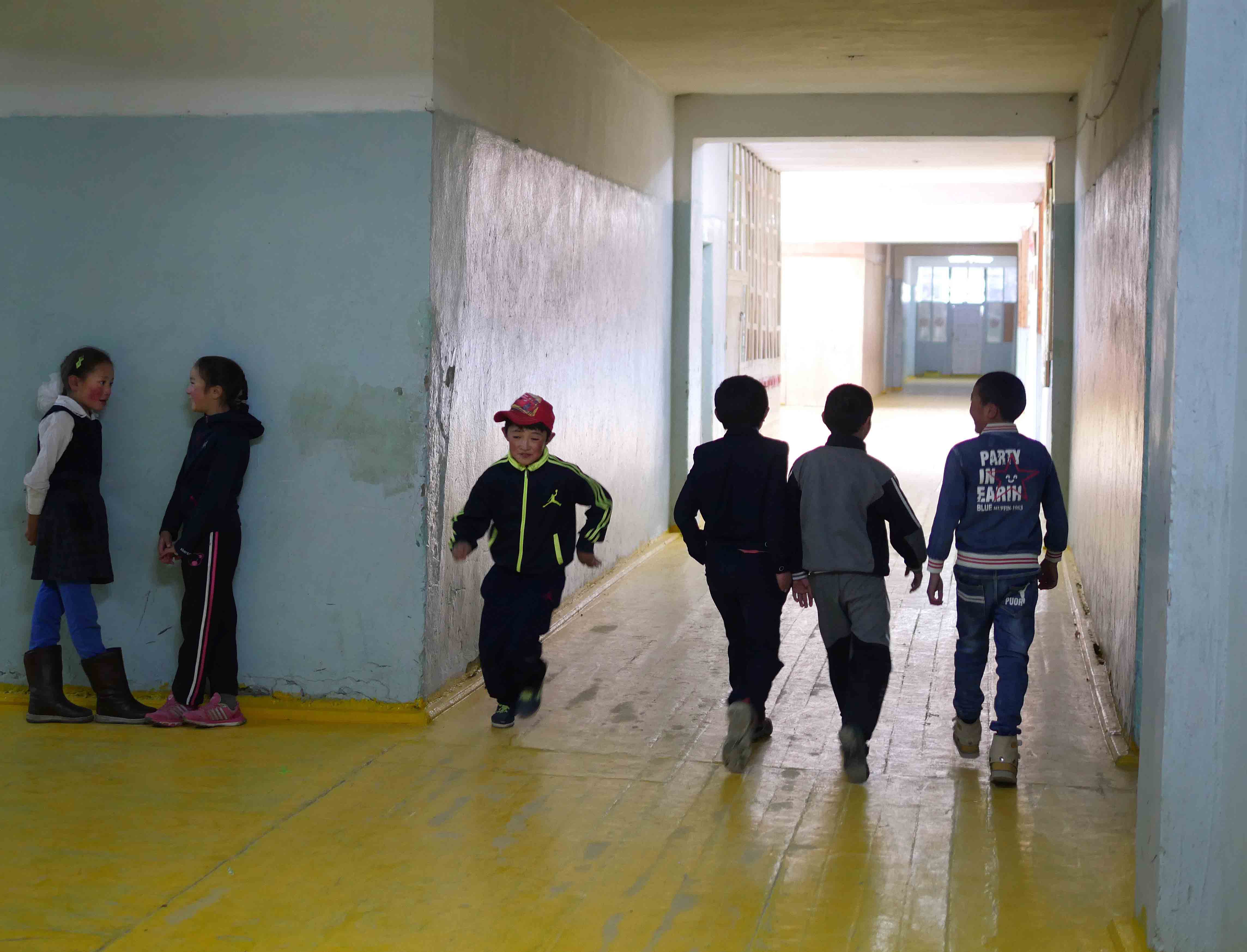 Akerke, on the left with a friend, in the school corridor before lessons begin.