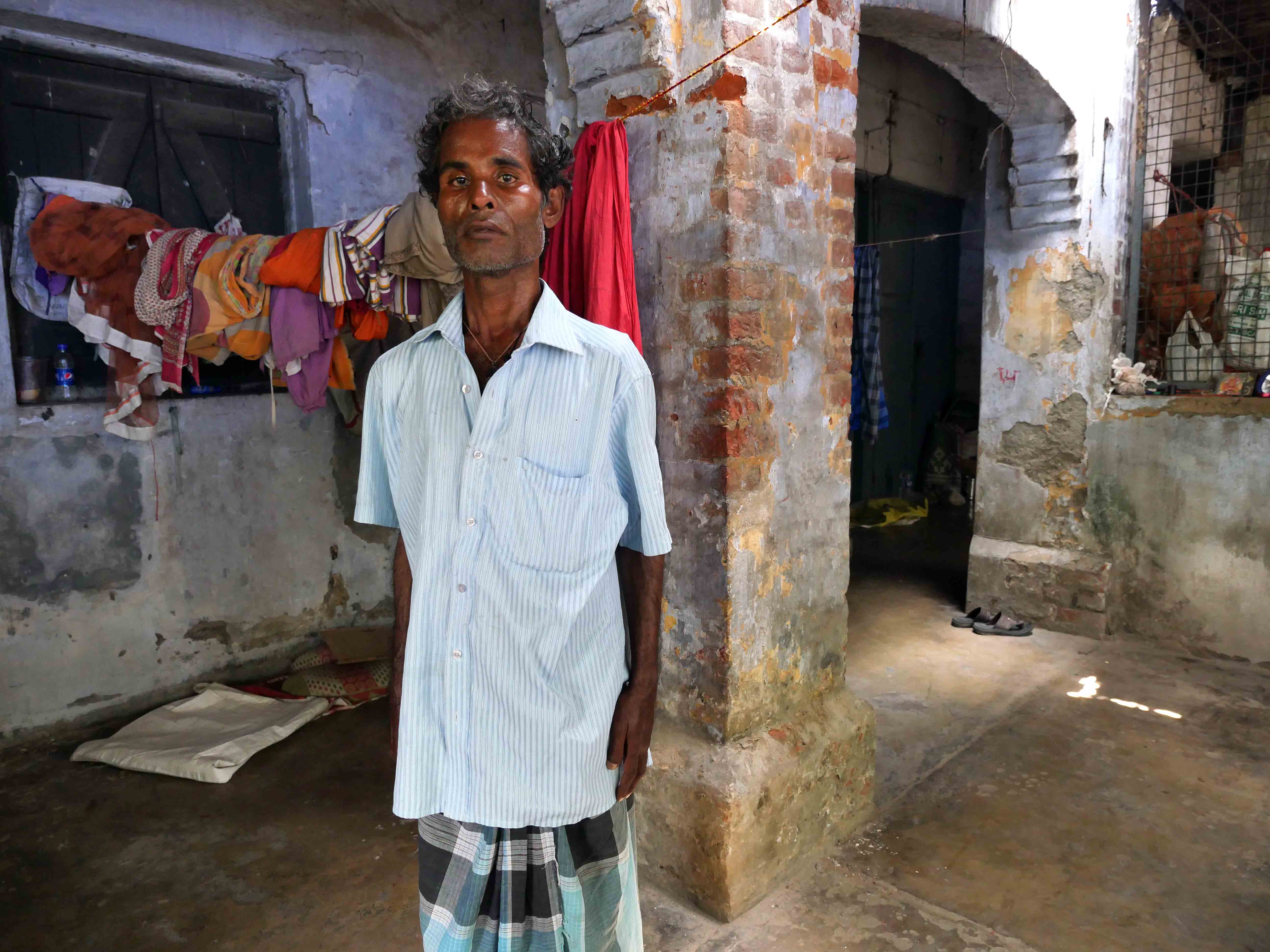 Sandip standing, no movement, expressionless face, hands by his side.